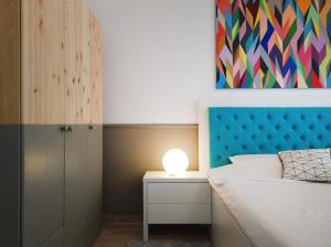 ママイアにあるThe One Mamaia Nordのベッドルーム1室(青いヘッドボードとランプ付きのベッド1台付)