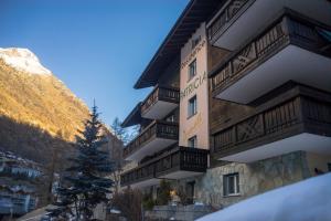 ein Gebäude mit einem Baum davor in der Unterkunft Apartments Patricia in Zermatt