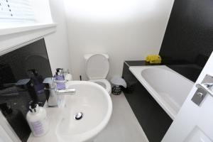 a bathroom with a sink and a toilet and a tub at Chapman's in Stornoway