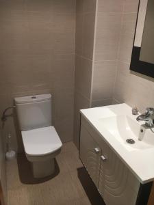 La salle de bains est pourvue de toilettes blanches et d'un lavabo. dans l'établissement La Casita Blanca, à Torreblanca