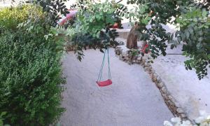 huśtawka wisząca na drzewie w ogrodzie w obiekcie Apartments Magda w mieście Supetar