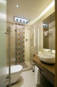 uma casa de banho com uma banheira, um lavatório e um chuveiro em Collage Taksim Hotel em Istambul