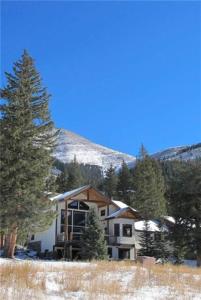 a house on a hill with trees and a mountain at 400 Whispering Pines in Blue River