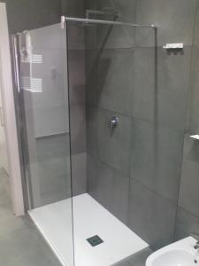 een douche met een glazen deur in de badkamer bij Diana Apartment in Valderice