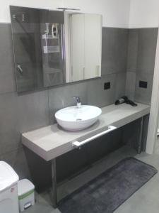 een badkamer met een witte wastafel en een spiegel bij Diana Apartment in Valderice