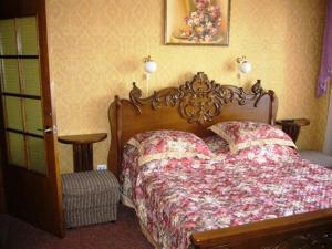 een slaapkamer met een bed met een houten hoofdeinde bij Hotel Profspilkovyi in Loetsk
