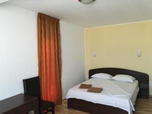 ママイア・ノルドにあるVila DGのベッドルーム1室(ベッド1台、赤いカーテン付)
