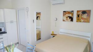 a white bedroom with a bed and a microwave at Lusso accessibile e Servizi in Lerici