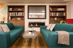a living room with two blue couches and a fireplace at 43 Station Hotel in Milan +83 photos
