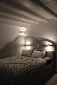 a bedroom with a bed with two pillows and two lights at Amorgos Pearls in Katapola