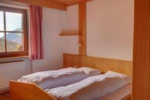 a bed in a room with a window at Gasthaus Furlhütte in Vipiteno