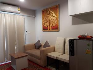 a living room with a couch and a chair at Rich Park@Tao poon interchange in Bang Su