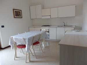 a kitchen with a table and chairs and a kitchen with white cabinets at B&B SoleLuna in Torretta
