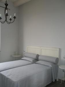 1 Schlafzimmer mit einem Bett mit weißer Bettwäsche und 2 Tischen in der Unterkunft Villa Marietta in Civitanova Marche