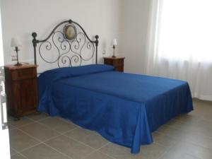 a bedroom with a blue bed with two night stands at Villa Marietta in Civitanova Marche