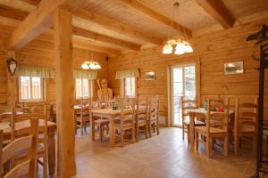 a dining room with wooden tables and chairs at Pension Roubenka in Harrachov