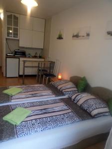 3 Betten in einem Zimmer mit Küche in der Unterkunft Apartments Leslie in Budapest