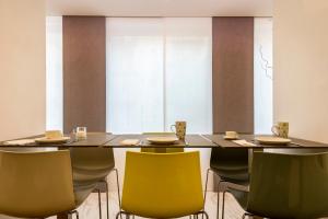 米蘭的住宿－43號車站酒店，一间带桌子和黄色椅子的用餐室