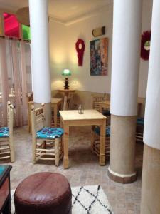 a living room with columns and a table and chairs at Jennat El Mossafir-Riad privé avec services in Essaouira