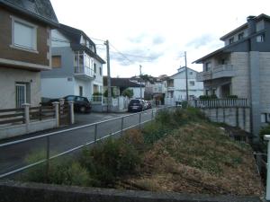 una strada con case e un'auto sulla strada di Hotel Severino a Ourense