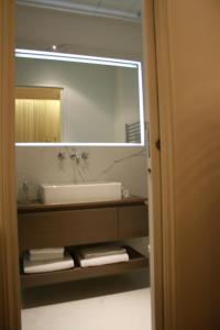 a bathroom with a sink and a large mirror at Cirque Deluxe Studio Apartment in Paris