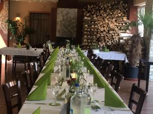 a long table in a restaurant with white tables and chairs at Mitte24 in Neu-Ulm