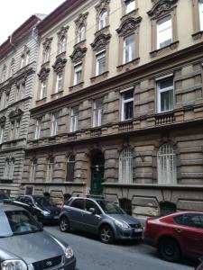 ブダペストにあるOsvat Apartmentsの車が目の前に停まった大きな建物