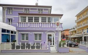 a purple house on a street with buildings at Residence Hotel Le Viole in Rimini