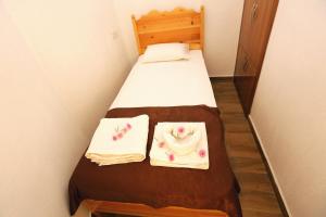 a small room with a bed with two towels on it at Dalyan Pension in Dalyan