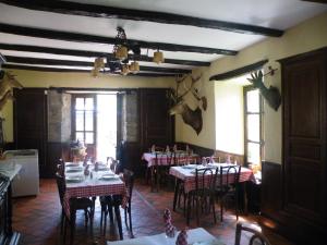 a dining room with tables and chairs in a restaurant at Hôtel des Voyageurs in Ferrières-Saint-Mary