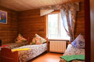 アルティバシュにあるGreen House at Teletskoye Lakeのベッド2台付きの客室で、キャビン内に窓があります。