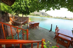 a wooden deck with tables and chairs next to a river at Dalyan Pension in Dalyan