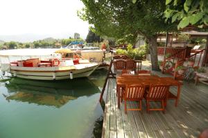 a boat sitting on the water next to a table and chairs at Dalyan Pension in Dalyan