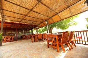 a wooden table and chairs under a wooden roof at Dalyan Pension in Dalyan