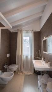 a bathroom with two sinks and a toilet and a window at Casa Vacanze Randelli in Ameglia