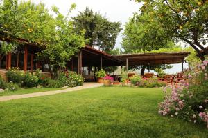 a garden in front of a building with flowers at Dalyan Pension in Dalyan