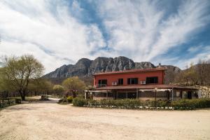 una casa su una strada sterrata con una montagna sullo sfondo di Locanda Belvedere Da Stefano a Rocchetta a Volturno