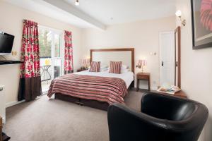a bedroom with a bed and a chair in it at Hawksmoor Guest House in Windermere