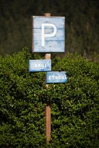 eine Stange mit Straßenschildern auf einem Busch in der Unterkunft Casa Rural Andutza in Ea