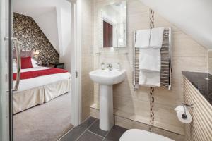 a small bathroom with a sink and a bed at Hawksmoor Guest House in Windermere
