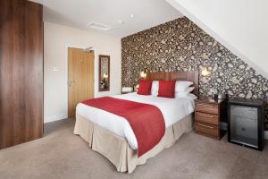 a bedroom with a large bed with a red blanket at Hawksmoor Guest House in Windermere