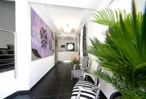 a hallway with black and white chairs and plants at Residence Hotel Le Viole in Rimini