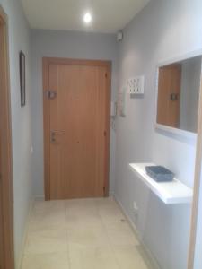 a bathroom with a wooden door and a sink at Apartamento Delfos in Salou