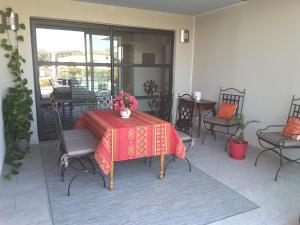 a patio with a table with a red table cloth at Aubade en Luberon in Cavaillon