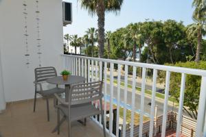 a balcony with a table and chairs and palm trees at Poseidono's Apartment in Paphos City