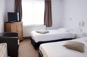 a hotel room with two beds and a flat screen tv at Hotel Halleux in Banneux