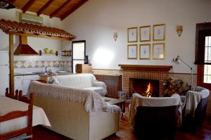 a living room with a fireplace and a couch and chairs at Casa Valeriana in Navaconcejo