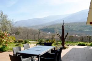 a table and chairs on a patio with mountains in the background at Casa Valeriana in Navaconcejo