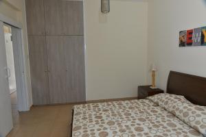 een slaapkamer met een bed en een houten kast bij Poseidono's Apartment in Paphos City