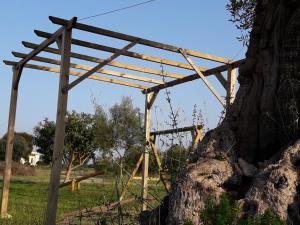 uma estrutura de madeira ligada a uma árvore em Villa Pugliese em Savelletri di Fasano